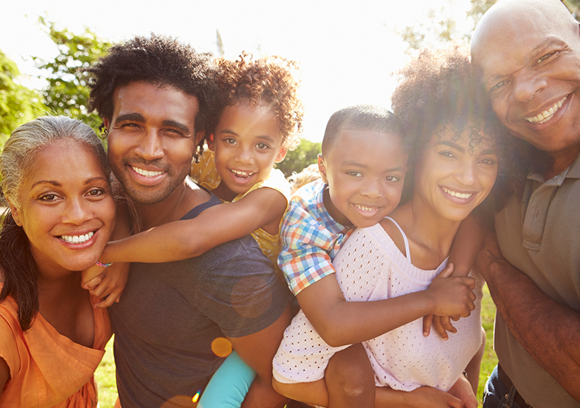 A portrait of a black multi-generation family in the park together